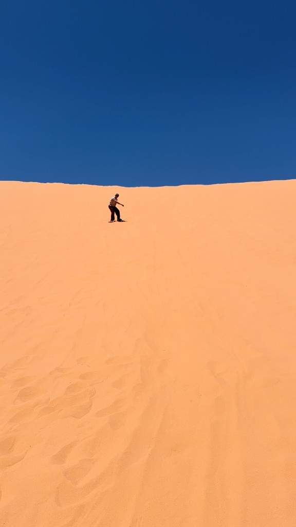 Sandboarding down a dune
