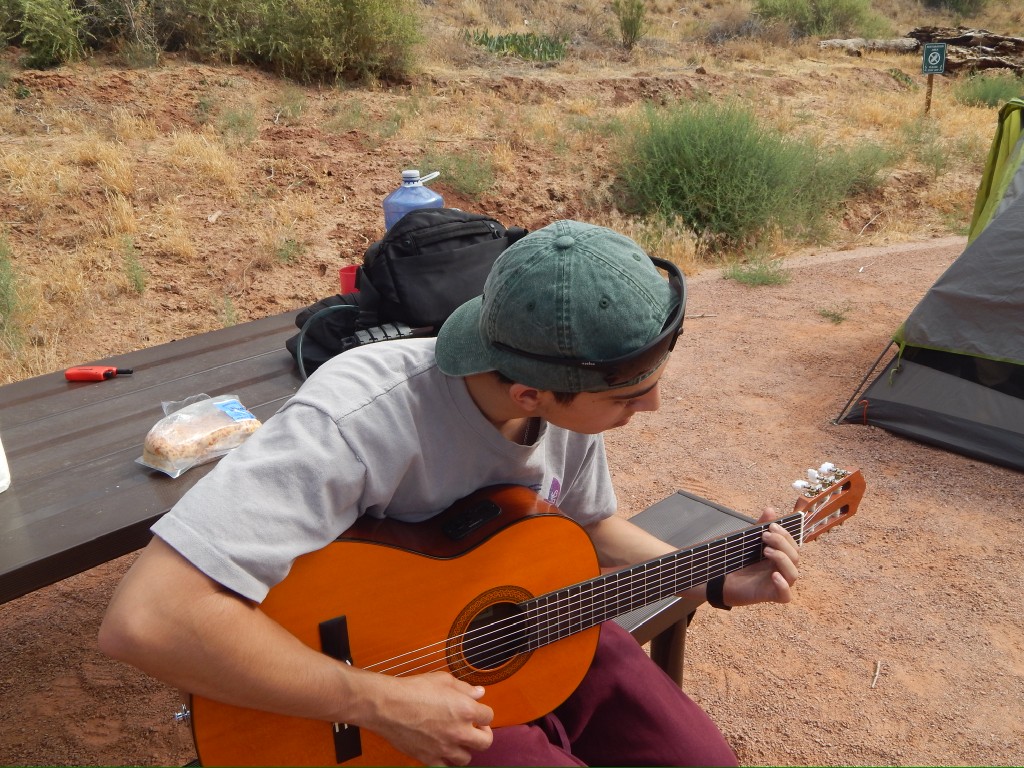 Playing acoustic guitar at a campsite